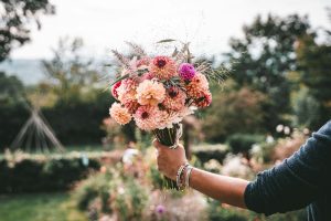 Hand holding a colourful bouquet of flowers, a gift for Mother's Day 2027