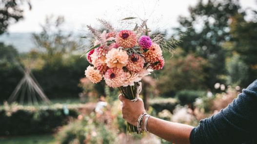 Hand holding a colourful bouquet of flowers, a gift for Mother's Day 2027