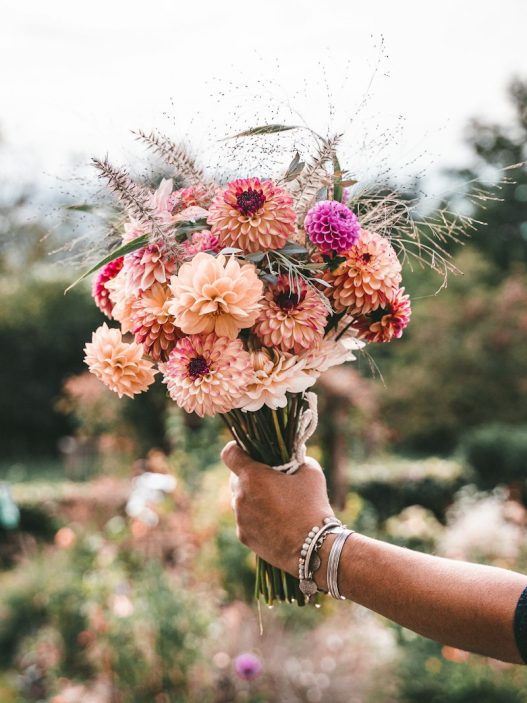 Hand holding a colourful bouquet of flowers, a gift for Mother's Day 2027