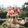 Hand holding a colourful bouquet of flowers, a gift for Mother's Day 2027