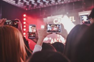 Concertgoers filming a night rock show in Buenos Aires on their phones, illustrating Indio Solari