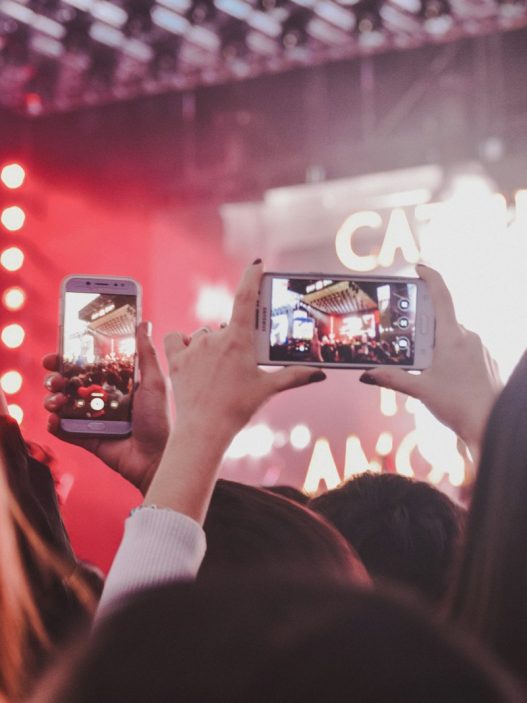 Concertgoers filming a night rock show in Buenos Aires on their phones, illustrating Indio Solari
