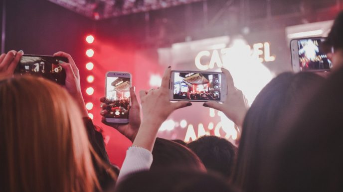 Concertgoers filming a night rock show in Buenos Aires on their phones, illustrating Indio Solari