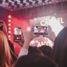 Concertgoers filming a night rock show in Buenos Aires on their phones, illustrating Indio Solari
