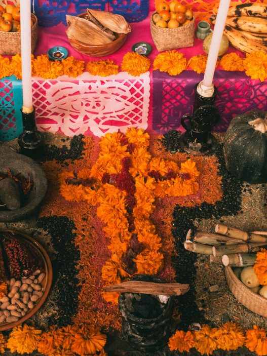 Day of the Dead ofrenda in Mexico with bread, fruit and marigold flowers